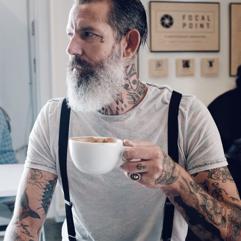 Guy with Tattoos Holding a Coffee Cappuccino